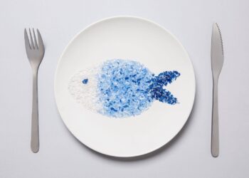 pesce di microplastiche su piatto con forchetta e coltello
